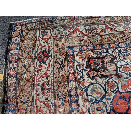 244 - A Persian Heriz hand woven carpet, having a central medallion on a red ground, framed by ivory colou... 