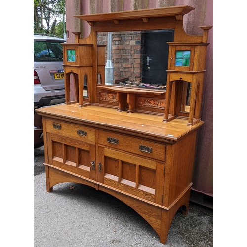 246 - An Arts & Crafts oak mirrored back sideboard, having a moulded flat top pediment above a central mir... 