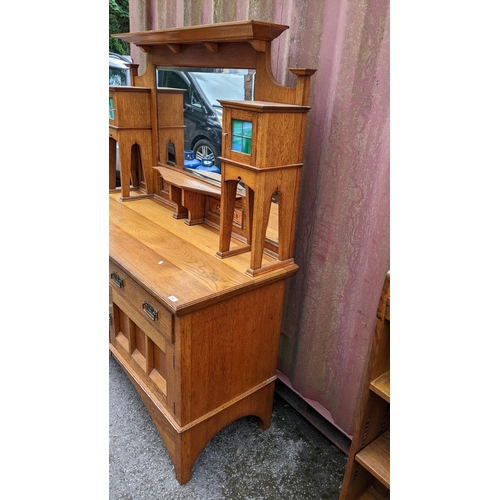 246 - An Arts & Crafts oak mirrored back sideboard, having a moulded flat top pediment above a central mir... 