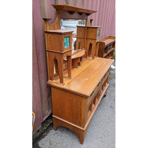 246 - An Arts & Crafts oak mirrored back sideboard, having a moulded flat top pediment above a central mir... 