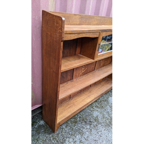 247 - A Liberty & Co oak Arts & Crafts bookcase attributed to the Cotswold Suit design, having a three qua... 