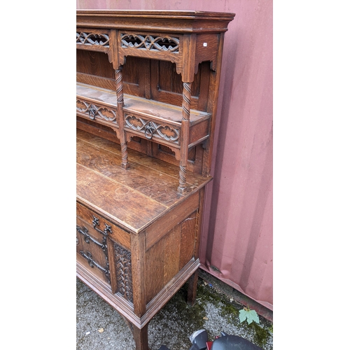 250 - An early 20th century Hampton & Sons Gothic revival oak dresser, the top having a moulded stepped co... 