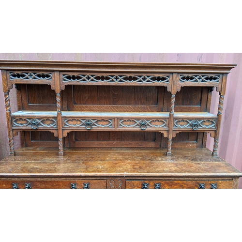 250 - An early 20th century Hampton & Sons Gothic revival oak dresser, the top having a moulded stepped co... 