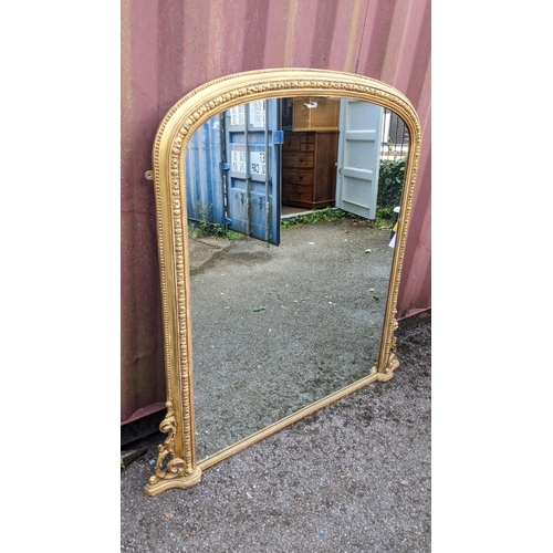 254 - A Victorian gilt wood over mantle mirror, the moulded arched topped frame having a beaded rim enclos... 