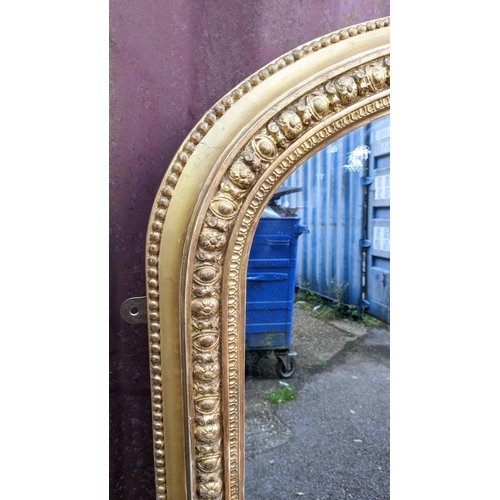 254 - A Victorian gilt wood over mantle mirror, the moulded arched topped frame having a beaded rim enclos... 