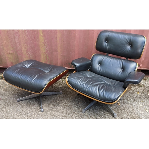 257 - A vintage black leather armchair and ottoman, after the design by Charles and Ray Eames for Herman M... 