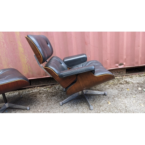 257 - A vintage black leather armchair and ottoman, after the design by Charles and Ray Eames for Herman M... 