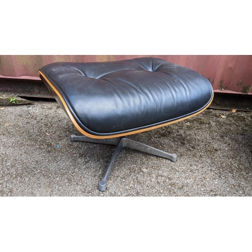 257 - A vintage black leather armchair and ottoman, after the design by Charles and Ray Eames for Herman M... 