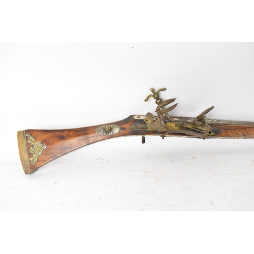 261 - A 19th century Middle Eastern flintlock action Jezail rifle, the barrel engraved with scroll design,... 