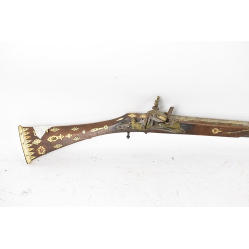 262 - A 19th century Middle Eastern flintlock action Jezail rifle, octagonal formed barrel, the stock inla... 