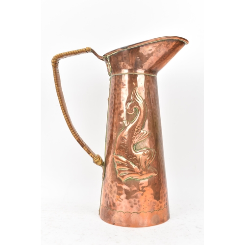 38 - A Newlyn Arts & Crafts copper jug of cylindrical tapering design with embossed fish decoration, rive... 