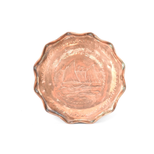 39 - A Newlyn style Arts & Crafts copper tray, having a wavy formed rim and engraved with a sailing boats... 