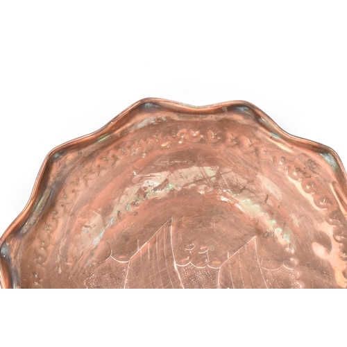 39 - A Newlyn style Arts & Crafts copper tray, having a wavy formed rim and engraved with a sailing boats... 