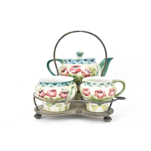 40 - A William Moorcroft (1872-1945) for James Macintyre & Co 'Rose and Poppy' three piece tea set with a... 