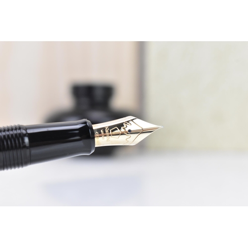 73 - A Namiki fountain pen, with a 14ct yellow gold nib, in black lacquer and relief decorated depicting ... 