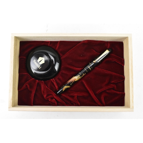 73 - A Namiki fountain pen, with a 14ct yellow gold nib, in black lacquer and relief decorated depicting ... 