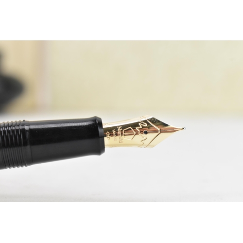 74 - A Namiki fountain pen, with a 14ct yellow gold nib, in black lacquer and relief decorated depicting ... 