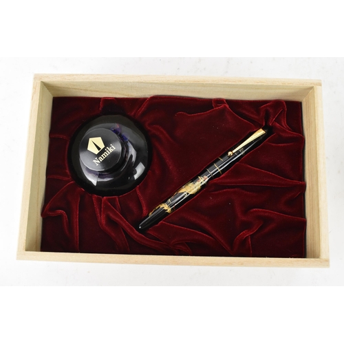 74 - A Namiki fountain pen, with a 14ct yellow gold nib, in black lacquer and relief decorated depicting ... 