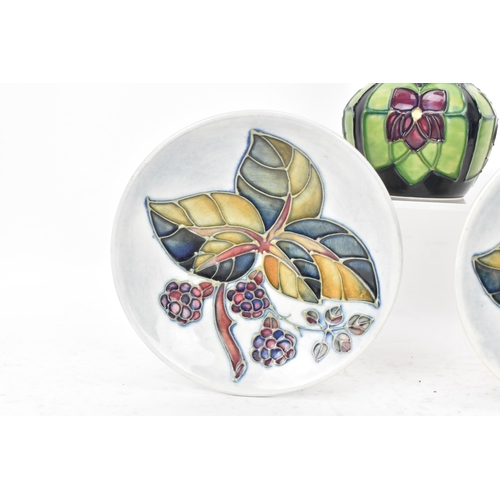 91 - Moorcroft pottery to include a pair of 'bramble' pattern pin dishes 11.5cm diameter and a 'violet' p... 