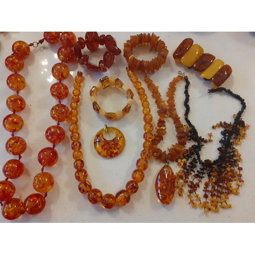 88 - Mixed vintage amber effect costume jewellery to include necklaces, one having a teardrop pendant on ... 