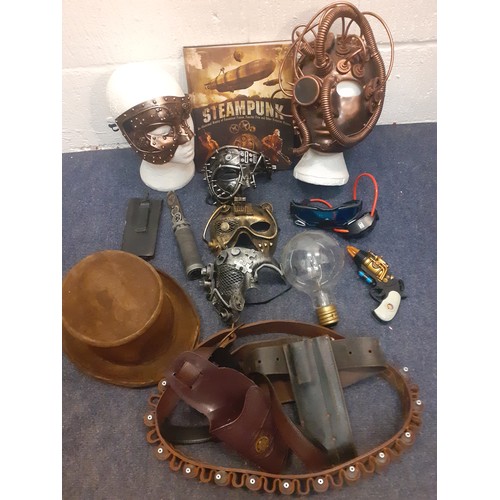 74 - Steampunk interest to include masks, belts, a book and a hat A/F all housed in a vintage green tin w... 