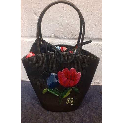 24 - Lulu Guinness- An embroidered black straw bag with floral cloth lining having a drawstring closure. ... 