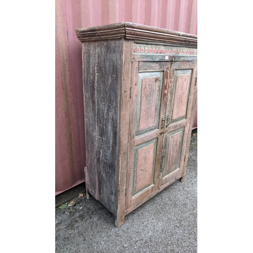 220 - An antique Indian part painted cabinet with a ceramic tile frieze above a pair of panelled doors 148... 