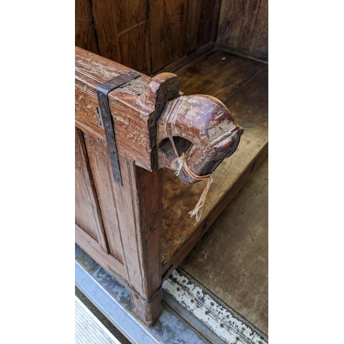 221 - An antique Indian teak bench with a panelled back and sides with carved horse handles 144cm x 91cm w... 