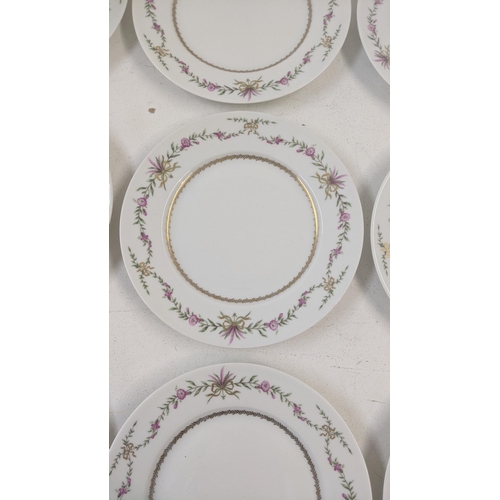 79 - A set of 12 Limoges side plates decorated with a floral design, together with a pair of Limoges cand... 