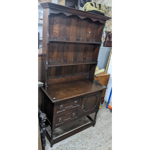 129 - An early 20th century oak small dresser having a plate rack above two drawers and a cupboard door 17... 