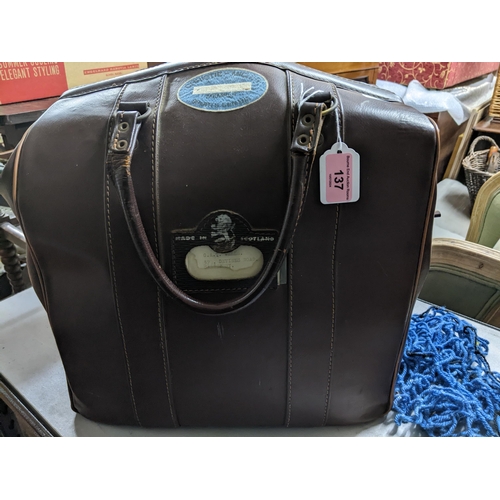 137 - A vintage leather holdall bag containing a sets of four Hemselite super grip championship lawn bowls... 