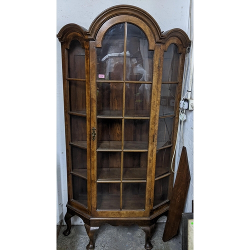 173 - An early 20th century walnut display cabinet with arched top, glazed door and sides, shaped internal... 