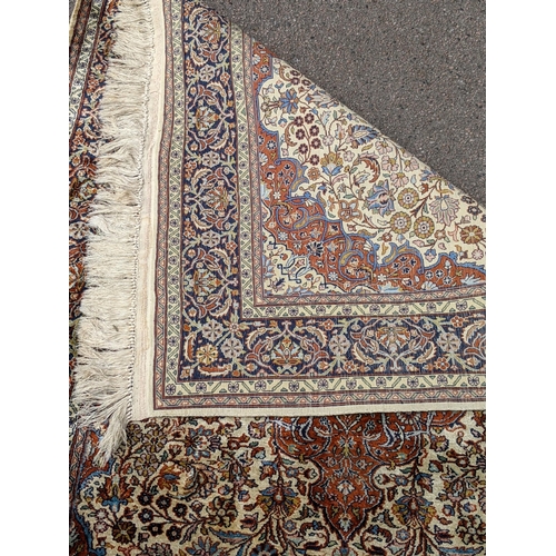 226 - A pure silk Persian Kashan rug with a central emblem decorated with a symmetrical abstract design wi... 