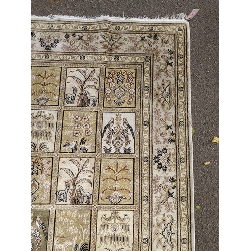 227 - A silk Turkish Hereke rug, the garden design, depicting different symbols and emblems in a 5x8 grid,... 