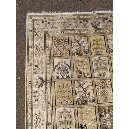 227 - A silk Turkish Hereke rug, the garden design, depicting different symbols and emblems in a 5x8 grid,... 