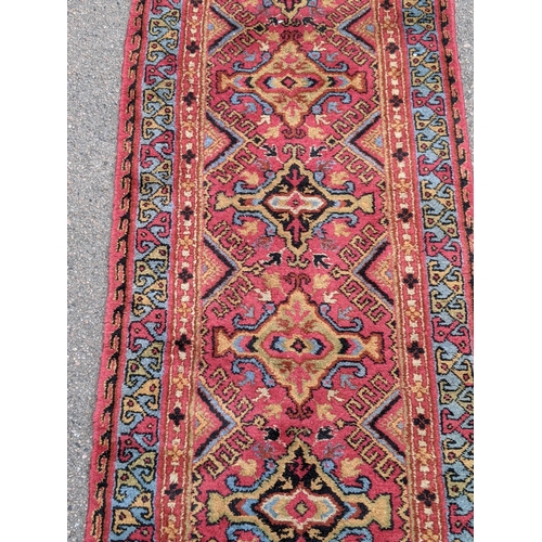 228 - A wool Eastern Turkestan Kashquai runner with eleven repeated central medallions five of one design ... 