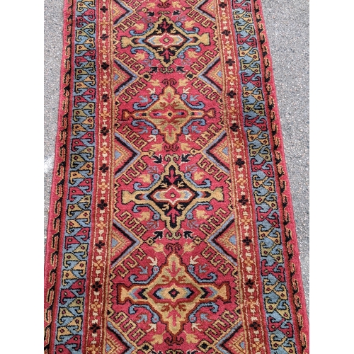 228 - A wool Eastern Turkestan Kashquai runner with eleven repeated central medallions five of one design ... 