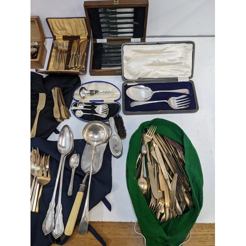 276 - Cutlery and flatware to include a brass canteen, silver plated serving set, basting spoons and other... 