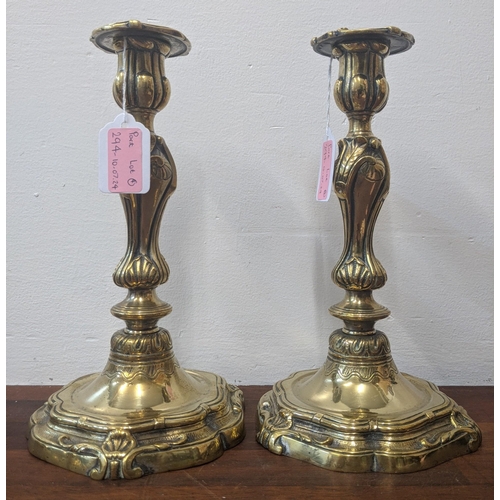 294 - Four brass candlesticks to include a pari decorated in an Art Nouveau style and an Arts and Crafts s... 