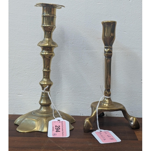 294 - Four brass candlesticks to include a pari decorated in an Art Nouveau style and an Arts and Crafts s... 