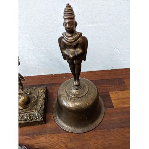 320 - Mixed collectables to include a Far Eastern style brass finished bell, a brass finished sculpture of... 