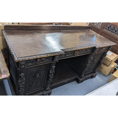 336 - A late 19th century Edwards & Roberts heavily carved oak sideboard having three drawers above an ope... 