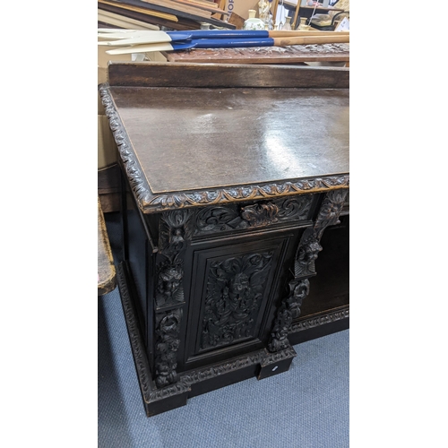 336 - A late 19th century Edwards & Roberts heavily carved oak sideboard having three drawers above an ope... 