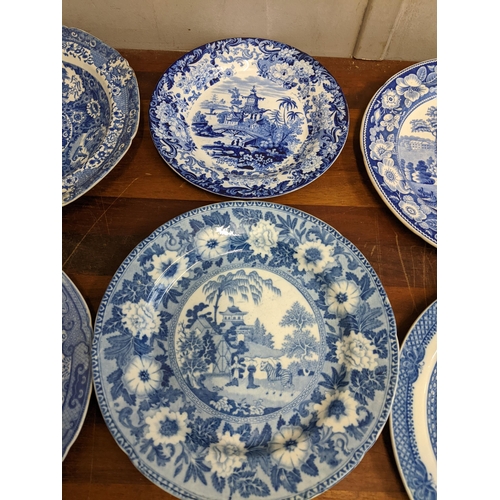 42 - A collection of blue and white patterned plates and dishes to include a Wedgwood example featuring a... 