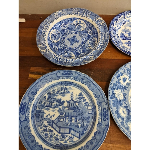 42 - A collection of blue and white patterned plates and dishes to include a Wedgwood example featuring a... 