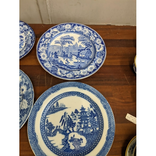 42 - A collection of blue and white patterned plates and dishes to include a Wedgwood example featuring a... 