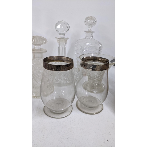 424 - Mixed glassware to include decanters, two late Victorian silver rimmed hurricane glasses and others
... 