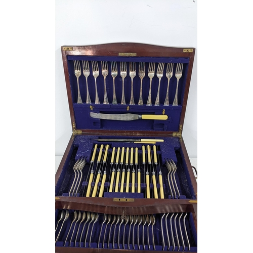 430 - An early 20th century canteen of silver plated cutlery, housed in a mahogany and boxwood inlaid case... 