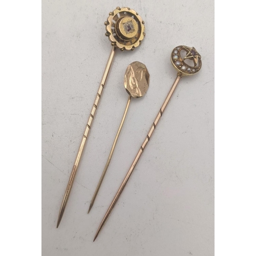 21 - Three gold stick pins all tested as 9ct gold to include a Victorian crescent moon and star stick pin... 