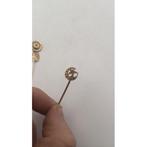 21 - Three gold stick pins all tested as 9ct gold to include a Victorian crescent moon and star stick pin... 